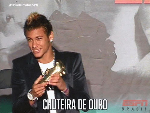 a man in a suit is holding a gold boot and the caption says chuteira de ouro