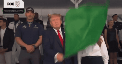 a man in a suit is holding a green flag in front of a fox advertisement