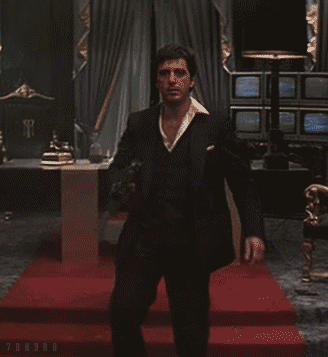 A Man In A Suit Is Holding A Gun In A Room With A Red Carpet And The Word Onsro On The Bottom Right GIF