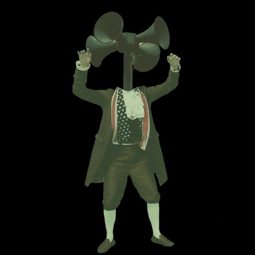 A Man In A Suit Is Holding A Megaphone In Front Of His Face GIF