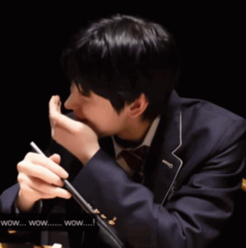 A Man In A Suit Is Holding A Pen In His Hand And Says Wow GIF