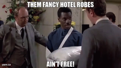 Man In Suit Holding Pillow Says Them Fancy Hotel Robes Ain't Free GIF