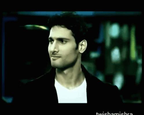 A Man In A Suit Is Holding A Red Umbrella In A Blurry Photo With The Words Twishamishra At The Bottom GIF