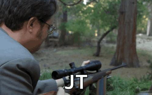 Man In Suit Holding Rifle JT GIF