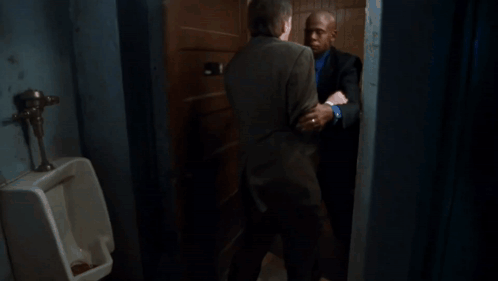 A Man In A Suit Is Holding Another Man 'S Neck GIF