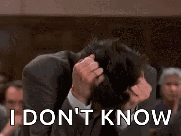 A Man In A Suit Is Holding His Head And Says `` I Don T Know '' . GIF