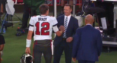 A Man In A Suit Is Hugging A Man In A Brady Jersey GIF