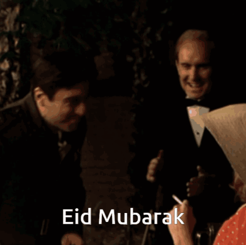 A Man In A Suit Is Hugging Another Man With The Words Eid Mubarak Written On The Bottom GIF