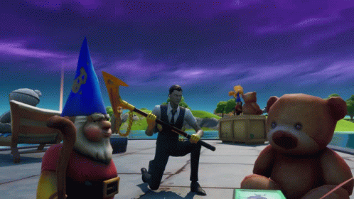 A Man In A Suit Is Kneeling Down Next To A Teddy Bear And A Gnome GIF
