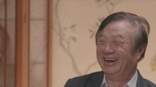A Man In A Suit Is Laughing With His Eyes Closed . GIF