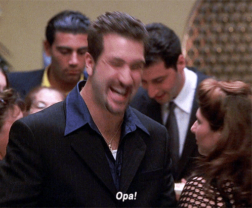 A Man In A Suit Is Laughing With The Word Opa Written On His Face GIF