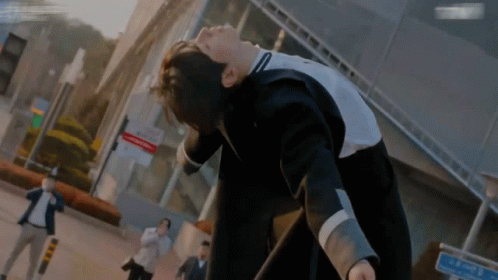 A Man In A Suit Is Laying On His Back In Front Of A Sign That Says ' A ' On It GIF