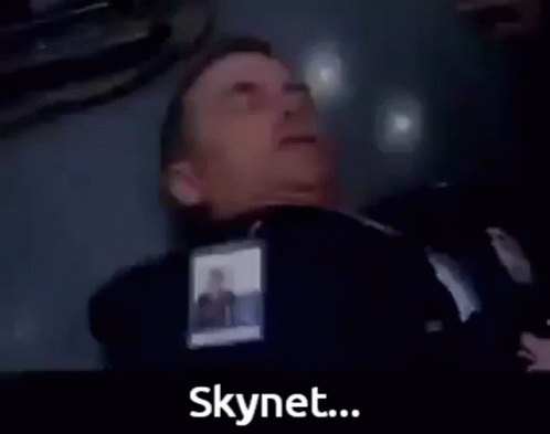 A Man In A Suit Is Laying On The Floor With The Words The Virus Has Infected Skynet Below Him GIF