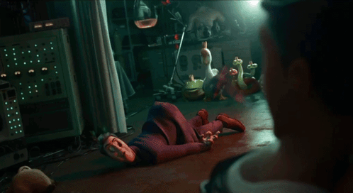 A Man In A Suit Is Looking At Another Man In A Dark Room GIF