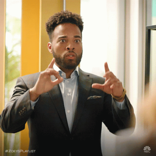 A Man In A Suit Is Making A Funny Face And Has The Hashtag #Zoeysplaylist At The Bottom GIF