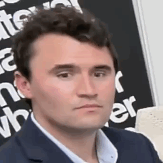 A Man In A Suit Is Making A Funny Face In Front Of A Blackboard . GIF