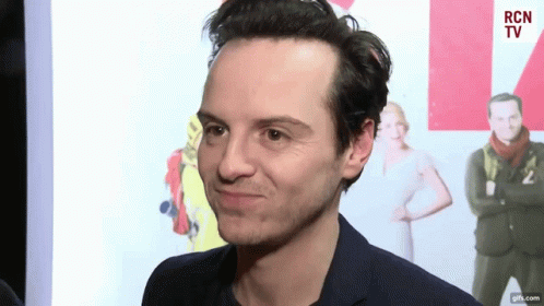 A Man In A Suit Is Making A Funny Face In Front Of A Rcn Tv Sign GIF