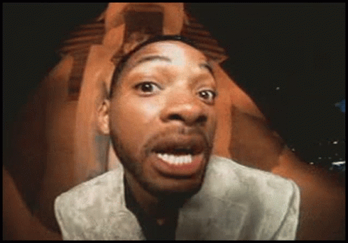 A Man In A Suit Is Making A Funny Face With His Mouth Open GIF