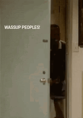 A Man In A Suit Is Peeking Out Of A Door With The Words Wassup Peoples Written On It . GIF