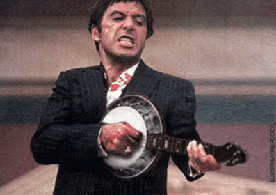 A Man In A Suit Is Playing A Banjo With Blood On His Shirt . GIF