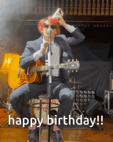 a man in a suit is playing a guitar and singing into a microphone with the words happy birthday written below him