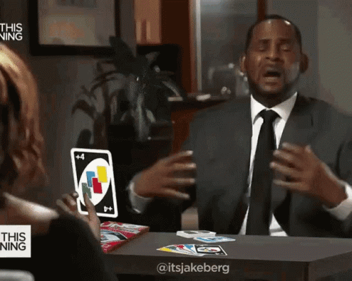 A Man In A Suit Is Playing Uno With A Woman GIF