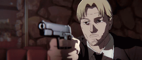 A Man In A Suit Is Pointing A Gun At The Camera GIF