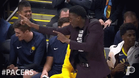A Man In A Suit Is Pointing At Another Man In A Black Shirt That Says " I Love You " GIF