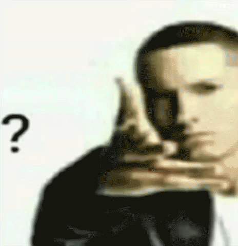 A Man In A Suit Is Pointing At Something With A Question Mark . GIF