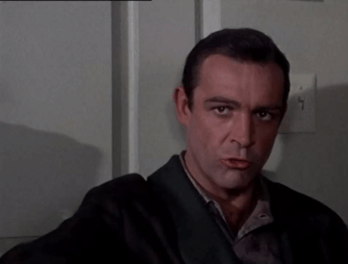 A Man In A Suit Is Pointing His Finger At The Camera GIF