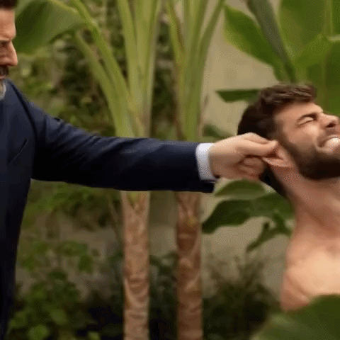 A Man In A Suit Is Putting His Hand On A Man 'S Ear . GIF