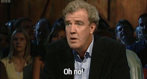 A Man In A Suit Is Saying Oh No In Front Of A Crowd GIF