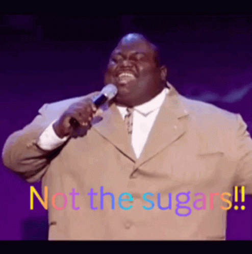 A Man In A Suit Is Singing Into A Microphone With The Words Not The Sugars Written On The Bottom GIF
