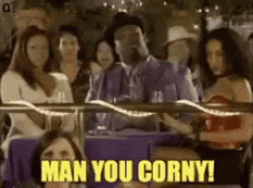 A Man In A Suit Is Sitting At A Table With A Group Of Women And Says Man You Corny . GIF