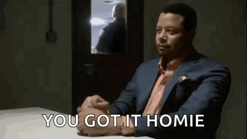 A Man In A Suit Is Sitting At A Table With His Hands Folded And The Words `` You Got It Homie '' . GIF