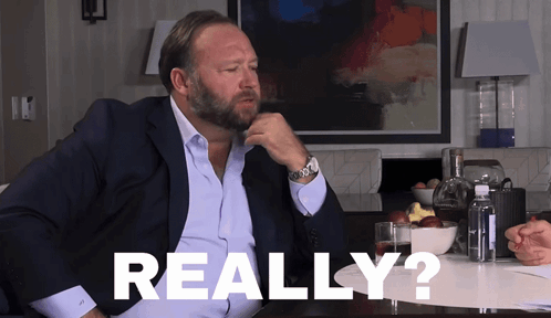 A Man In A Suit Is Sitting At A Table With The Word Really Written On The Table GIF