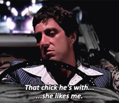 A Man In A Suit Is Sitting In A Car And Saying That Chick He 'S With She Likes Me . GIF