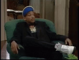 A Man In A Suit Is Sitting In A Chair With His Feet Up GIF