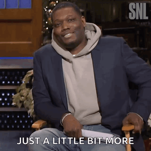 A Man In A Suit Is Sitting In A Chair With The Words Just A Little Bit More Behind Him GIF