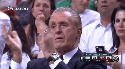 A Man In A Suit Is Sitting In A Crowd Watching A Basketball Game Between Indiana And Miami GIF