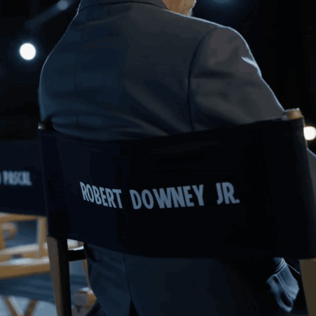 A Man In A Suit Is Sitting In A Director 'S Chair With Pedro Pascal Written On The Back GIF