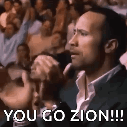 A Man In A Suit Is Sitting In Front Of A Crowd And Saying `` You Go Zion !!! '' GIF