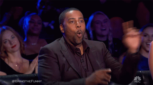 a man in a suit is sitting in front of a crowd with the hashtag bringthefunny