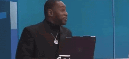 A Man In A Suit Is Sitting In Front Of A Laptop Computer And Says `` That Was Crazy '' . GIF
