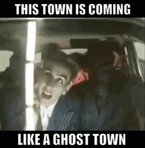 A Man In A Suit Is Sitting In The Back Seat Of A Car . GIF