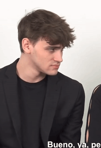 A Man In A Suit Is Sitting Next To A Woman And Says Bueno GIF
