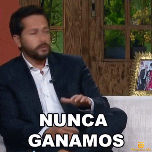 a man in a suit is sitting on a couch and saying " nunca ganamos "