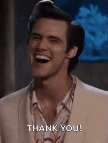 A Man In A Suit Is Smiling And Saying Thank You . GIF