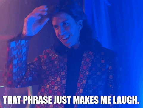 A Man In A Suit Is Smiling And Says That Phrase Just Makes Me Laugh . GIF