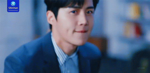 A Man In A Suit Is Smiling With A Shinhan Logo In The Background GIF